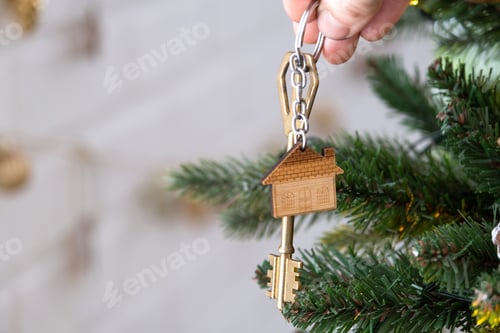 Preview: KKey to the house with a keychain is hanging on the Christmas tree. A gift for New Year, Christmas