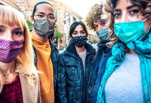 Preview: Community of multiracial people covered by facemasks looking at camera outdoors