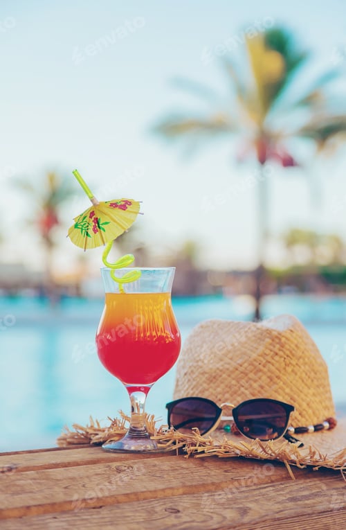 Refreshing Cocktail with Straw Hat by Poolside