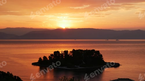 Preview: Small island with tree silhouettes in the sea in Corfu, Greece at scenic sunset