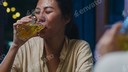 Preview: Group of happy tourist young Asia friends drinking alcohol and having hangout party in night club.
