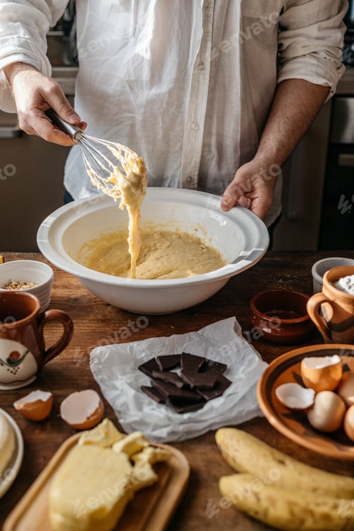 Preview: Man baking banana bread at home, on a sunny day.