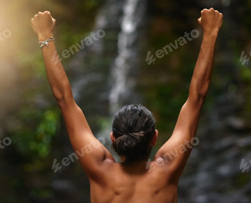 Preview: Rearview shot of an unidentifiable person celebrating a victory in the jungle
