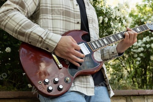 Preview: Attractive young guy playing guitar in the park