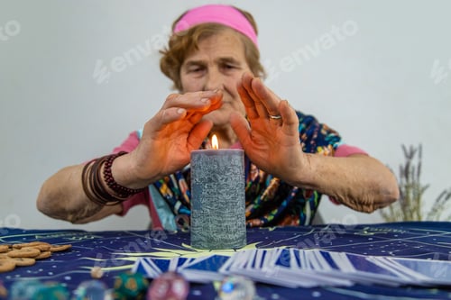 Preview: Woman fortune teller fortune telling on a candle. Selective focus.