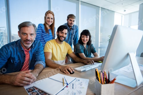 Preview: Creative business team working together on desktop pc in office