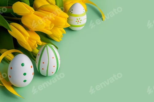 Preview: Easter eggs and yellow tulips on a green background.