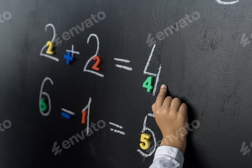 Preview: cropped shot of child studying numbers on chalkboard
