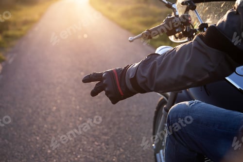 Preview: Close-up of a biker's hand showing the hand gesture of salute, the V gesture
