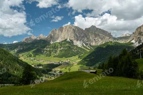 Preview: Scenic green landscape at Alta Badia Dolomites Italy with mountains and cloudscape in the background