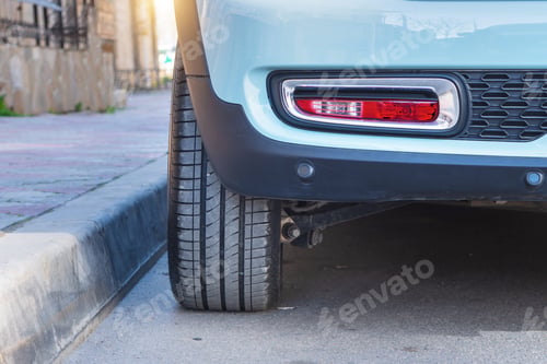 Preview: Close-up of car tires and wheel parked on asphalt