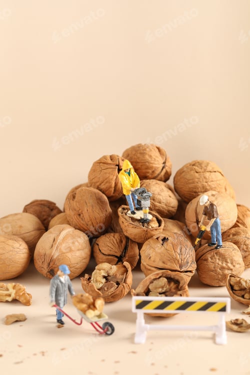 Preview: Vertical closeup shot of small construction worker figurines working on nuts