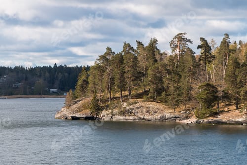 Preview: view from the ship to the rocky coast of Sweden. typical swedish houses on the rocks. cloudy sky