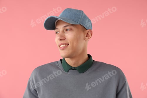 Preview: Young man in stylish baseball hat on pink background