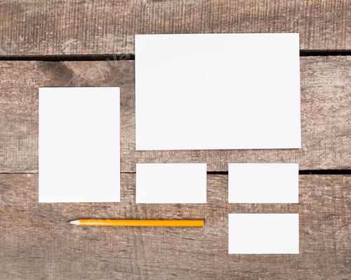 Preview: Blank stationery arranged neatly on a rustic wooden surface in natural light