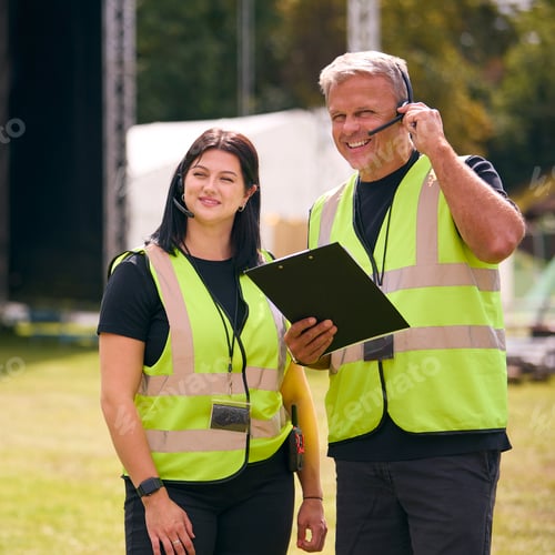 Preview: Production Team Talking On Headsets Setting Up Outdoor Stage For Music Festival Or Concert