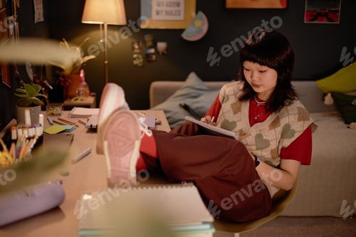 Preview: Young Adult Drawing at Desk in Cozy Room