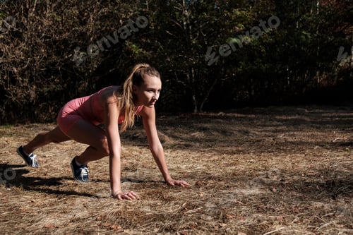 Preview: Portrait of young caucasian woman doing stretching exercise in a forest near London.