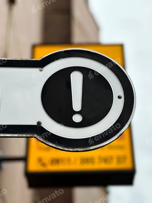 Preview: Round Warning Sign "Exclamation Mark" On Yellow Background In The City