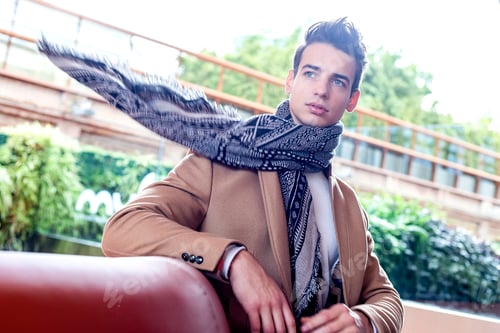 Preview: man sitting down outdoors on a bench on a cold fall day wearing a scarf