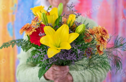 Preview: Senior caucasian woman holding a bouquet of flowers isolated on colorful background. Valentine's Day