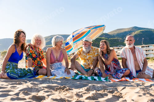 Preview: Happy group of senior friends bonding at the beach during summertime