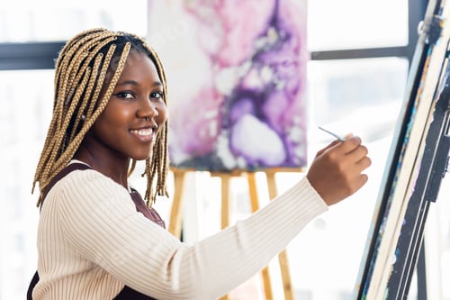 Preview: brazilian woman with dreadlocks in white blouse in art studio