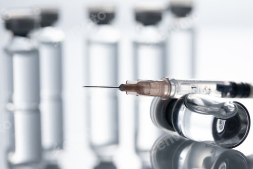Preview: Closeup shot of covid19 vaccine bottles and a needle on a white background - covid19 concept
