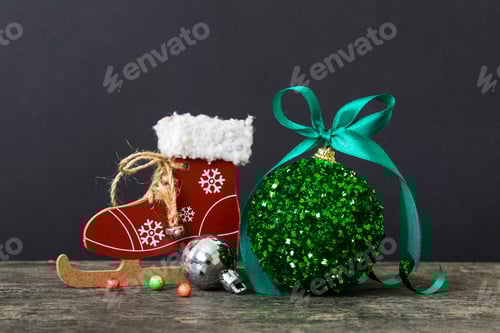 Preview: Christmas ball with skates on colored background. decoration bauble with ribbon bow with copy space