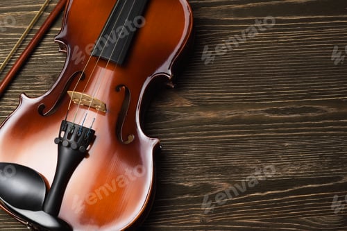 Preview: Violin with bow on brown wooden table.