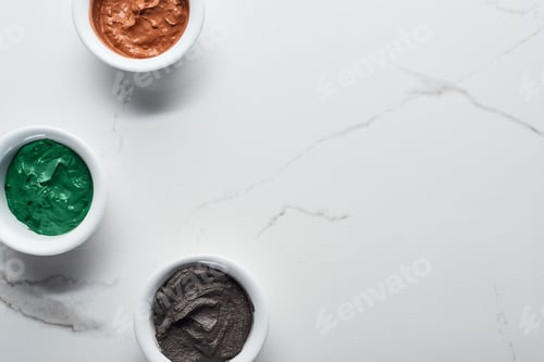 Preview: Top View of Cups With Diverse Natural Beauty Products on Marble Surface