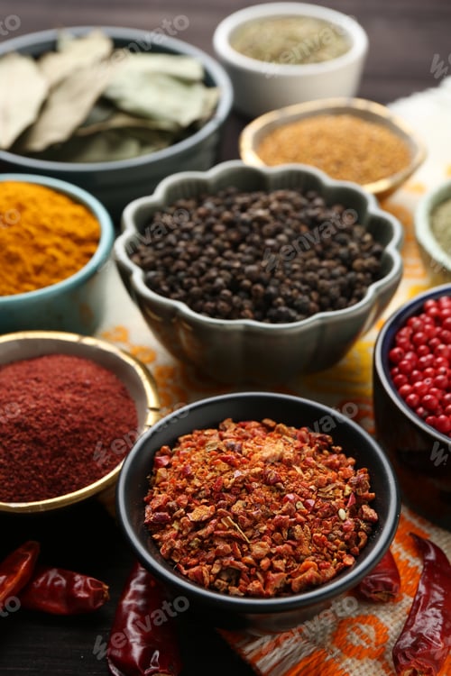 Preview: Different aromatic spices on orange tablecloth, closeup