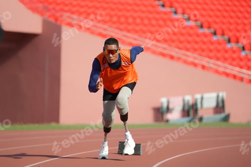Preview: Asian para-athletes with prosthetic blades sprint on a running track at stadium.