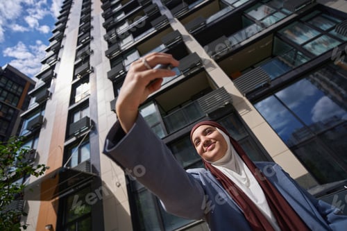 Preview: Woman in hijab and jacket taking a selfie