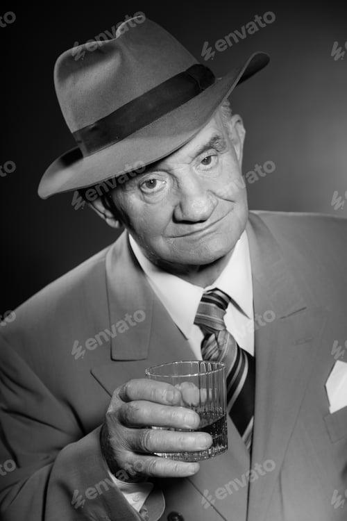 Preview: Senior Glamour Vintage Man Wearing Suit And Tie And Hat. Black And White Studio Shot. Gangster