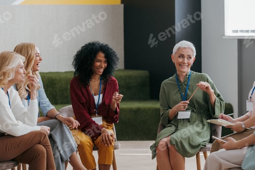 Preview: Confident mature women communicating and smiling while visiting group training class