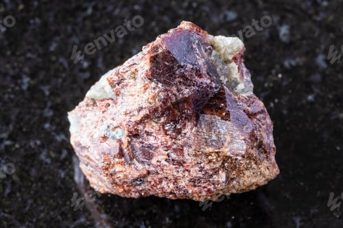Preview: sample of raw eudialyte mineral on black granite
