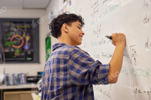 Preview: Teen student writing equation on whiteboard in classroom