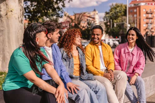 Preview: Group of diverse friends enjoying conversation outdoors in urban setting