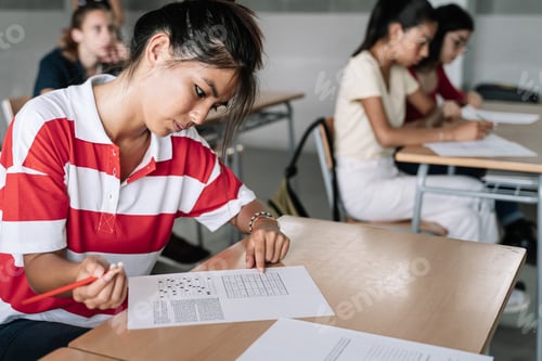 Preview: Female Asian Student writing exam exercise in the college high school classroom