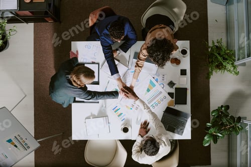 Preview: Business Professionals Shaking Hands Around Meeting Table