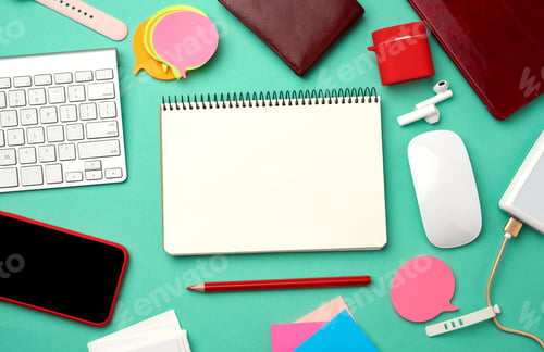 Preview: Paper notebook, keyboard, power bank with cable, red smartphone with blank black empty screen
