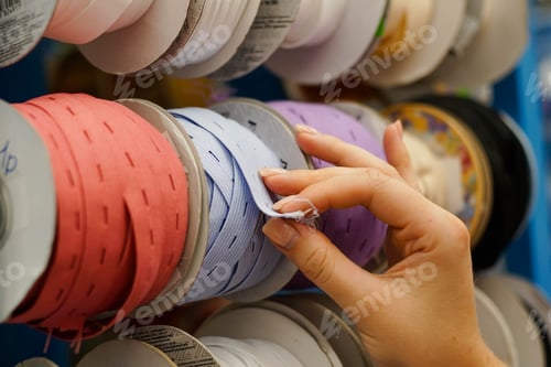 Preview: Close Up Of Colorful Ribbons. Girl Hand Choosing Ribbons in Needlework Store. Sewing Shop Center.