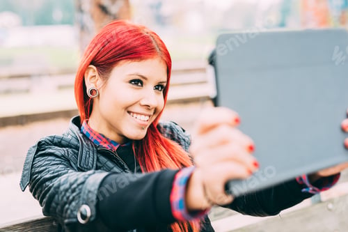 Preview: Half length of young beautiful hispanic redhead woman with tablet handhold taking selfie