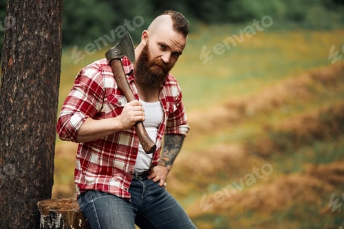 Preview: Lumberjack sitting in forest resting after hard work