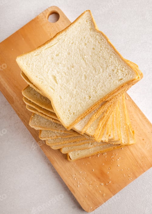 Preview: Pile of toasted bread slices on cutting board for breakfast. Isolated. Bright background.