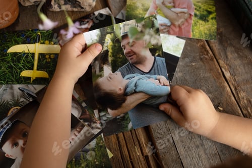 Preview: Photo printing concept. Preschooler boy hands holding printed photos.