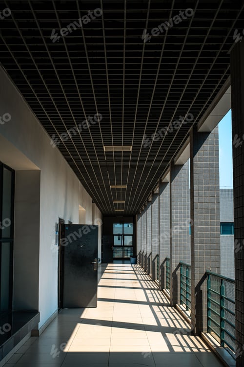 Preview: Long, narrow hallway with white walls on one side and metal railings on the other