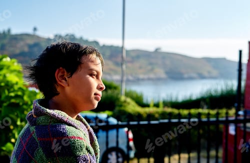Preview: pensive boy in a bathrobe in summer