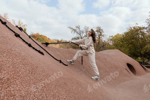 Preview: Young girl in light tracksuit doing sports